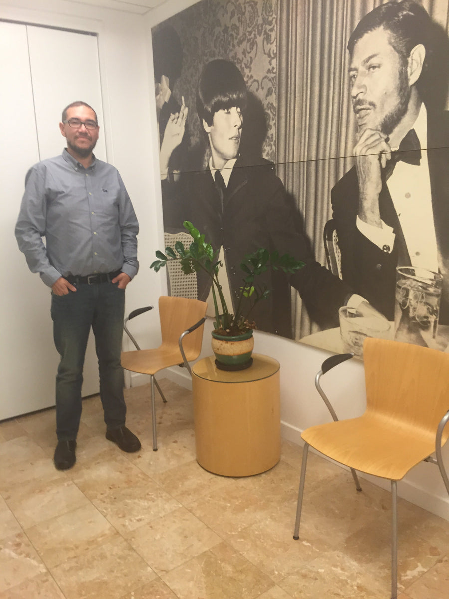 Person standing in a room with a large black and white photograph on the wall.
